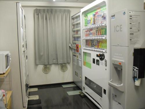 a laboratory room with a refrigerator and some drinks at Hotel Vista Atsugi in Atsugi