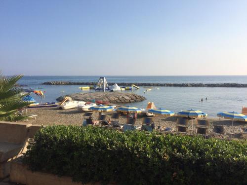 a beach with chairs and umbrellas and the water at Bistrot del mare in Santo Stefano al Mare