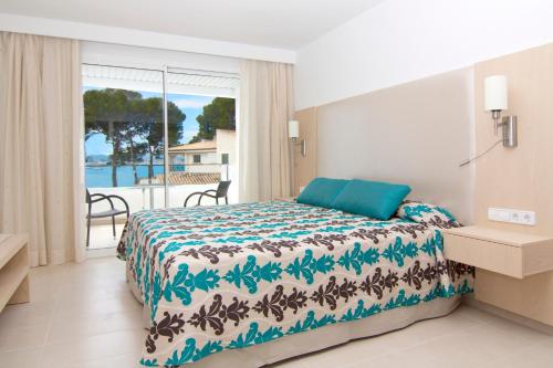 um quarto com uma cama e vista para o oceano em Hoposa Pollensamar Apartamentos em Port de Pollença