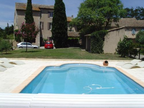 une piscine dans une cour avec une maison dans l'établissement Le Gite du Moulin de Milan, à Cheval-Blanc