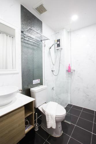 a bathroom with a toilet and a glass shower at House of Happiness in Bangkok