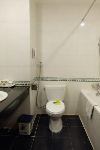 a white bathroom with a toilet and a sink at Indochine Hotel in Kon Tum