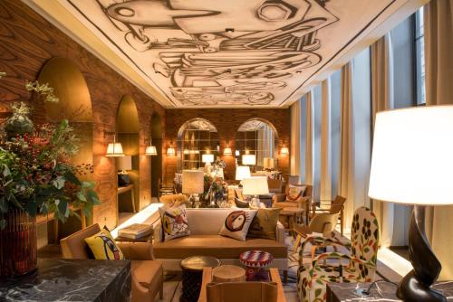 - un hall d'un hôtel avec des canapés et des chaises dans l'établissement Brach Paris - Evok Collection, à Paris