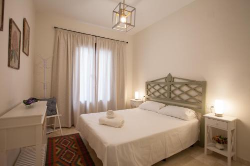 een slaapkamer met een wit bed en een raam bij Apartamento De Lujo En Antiguo Convento in Granada