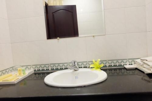 a white sink in a bathroom with a mirror at Indochine Hotel in Kon Tum