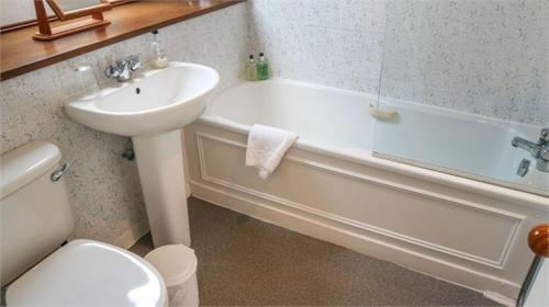 a bathroom with a sink and a tub and a toilet at Gladstone House in Kirkcudbright