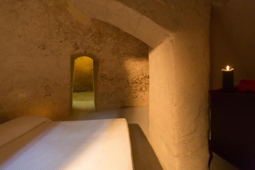 a small room with a bed and a candle at San Giovanni Vecchio - Residenza in Matera