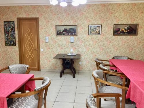 Un comedor con mesas y sillas rosas. en Green Canyon Uzbekistan, en Yusufkhona