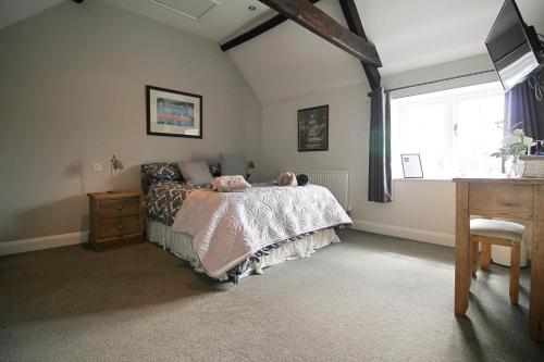 a bedroom with a bed and a window and a desk at The Globe Inn Alvington in Alvington
