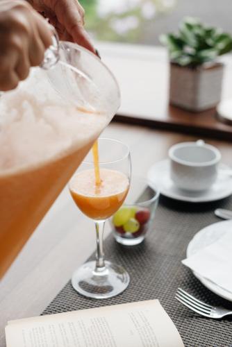 a person pouring a drink into a martini glass at Hotel Bodega EL GRIFO in San Bartolomé