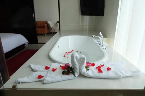 a white sink with two towels with flowers on it at Indochine Hotel in Kon Tum