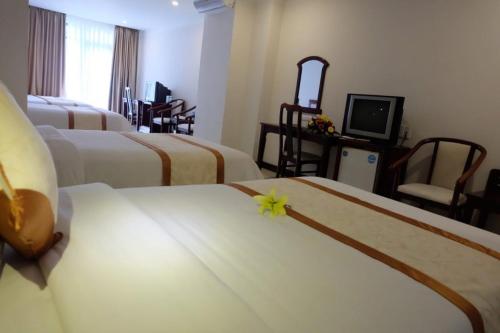a hotel room with four beds with a flower on the bed at Indochine Hotel in Kon Tum