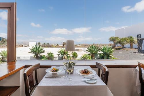 a dining room with a table and a view of the desert at Hotel Bodega EL GRIFO in San Bartolomé