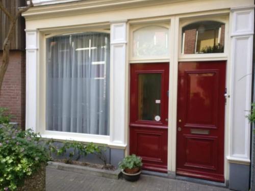 a red door and windows on a house at Bed & Breakfast WestViolet in Amsterdam