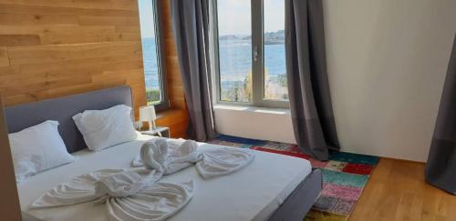 uma cama num quarto com uma grande janela em Villa Cape Vergoti em Lozenets