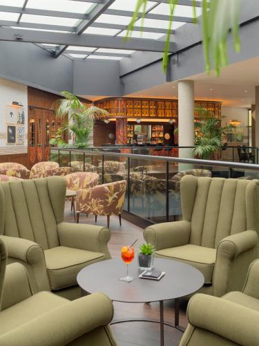 a lobby with chairs and a table and a bar at H10 Marina Barcelona in Barcelona