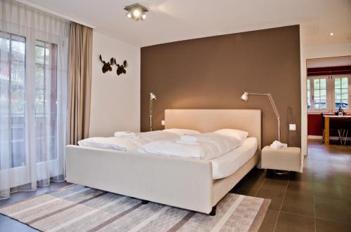 1 dormitorio con 1 cama blanca grande en una habitación en Apartment Felix - GRIWA RENT AG en Grindelwald