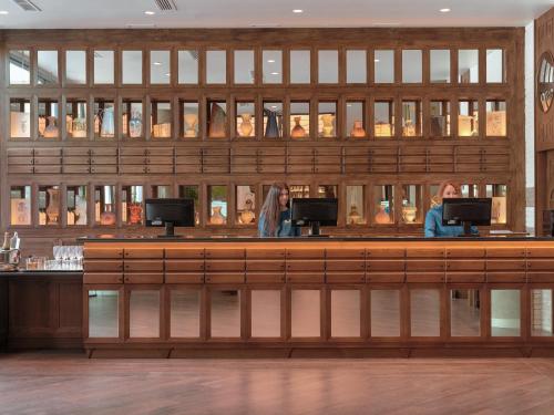 two women sitting at a bar in a restaurant at H10 Marina Barcelona in Barcelona