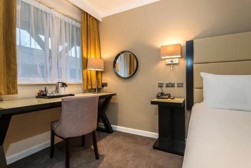 a hotel room with a bed and a desk and a bedroom at New Place in Fareham