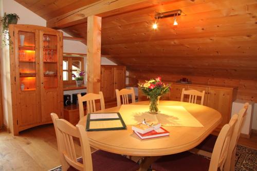 a dining room with a wooden table and chairs at Sonnhof's Ferienresidenz in Reit im Winkl
