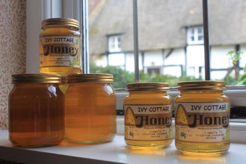 four jars of honey sitting on a window sill at IVY COTTAGE B and B in Buckingham