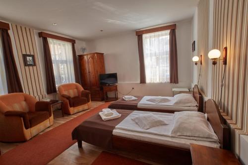 a hotel room with two beds and two chairs at Pensiunea Daniel in Sibiu