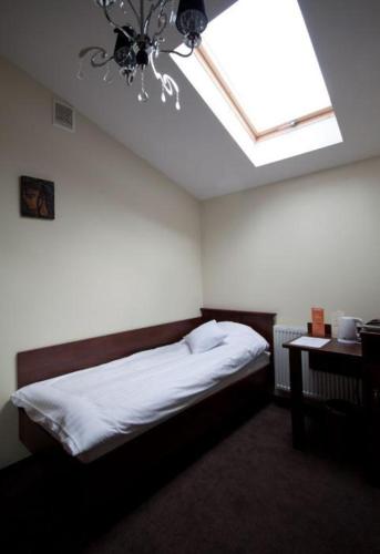 a bedroom with a bed and a ceiling with a chandelier at Noclegi Nad Osławą in Zagórz