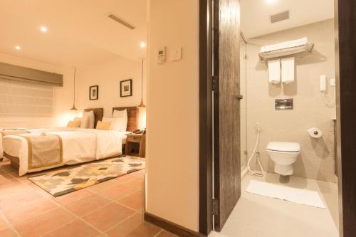 a bedroom with a bed and a bathroom with a toilet at Hotel Roadhouse, Thamel, Kathmandu- Contemporary Boutique in Kathmandu