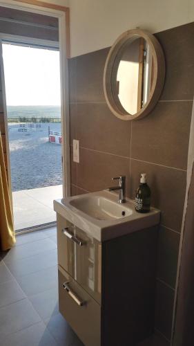 une salle de bain avec un lavabo et un miroir dans l'établissement Le Cottage de la Doucette, à Paimpont