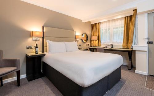 a hotel room with a large bed and a desk at New Place in Fareham
