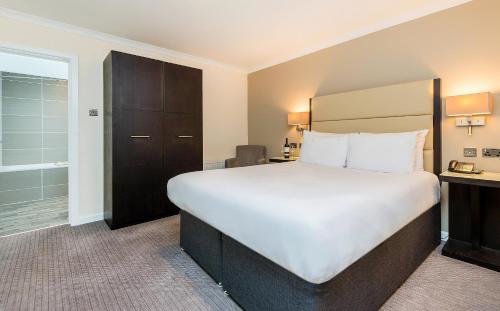 a hotel room with a large bed and a bathroom at New Place in Fareham