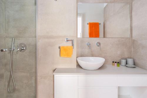 ein Badezimmer mit einem weißen Waschbecken und einer Dusche in der Unterkunft Frishman Dream by Five Stay in Tel Aviv