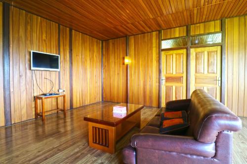 a living room with a leather couch and a table at Villa Gardenia Bandung in Lembang