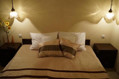 a bedroom with a bed with two pillows and two lights at Villa Amber in Sarbinowo