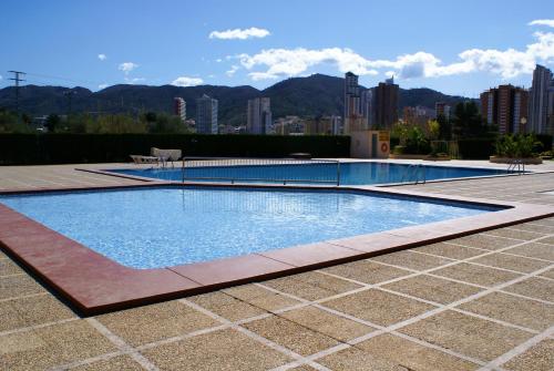 a swimming pool with a city in the background at Apartamentos Paraiso 10 in Benidorm