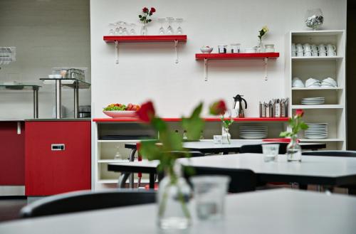 a restaurant with tables and chairs and red shelves at Motel Skive in Skive