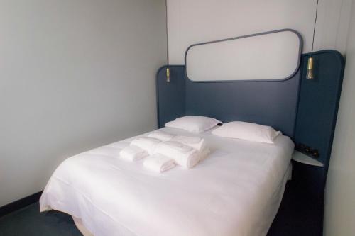 un lit avec des draps blancs et des serviettes dessus dans l'établissement Joie Paris Quartier Latin, à Paris