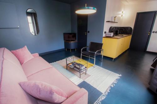 un salon avec un canapé rose et une table dans l'établissement Joie Paris Quartier Latin, à Paris