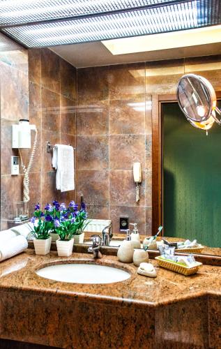 a bathroom with a sink and a large mirror at Hotel Panorama in Thessaloniki