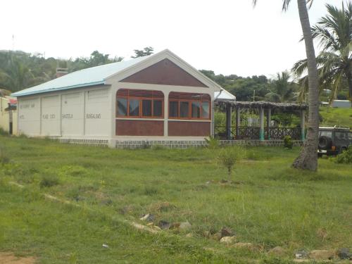 a white and red house with a tree in a field at SANJEELA-PLAGE COCO in Diego Suarez
