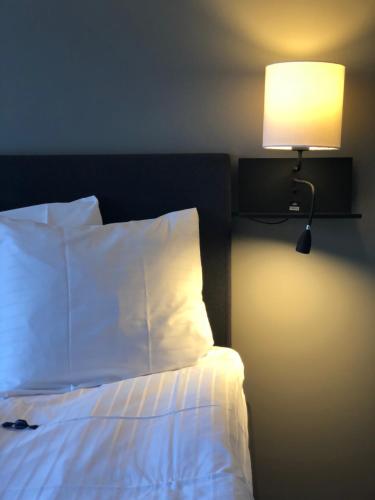 a bedroom with a bed with a lamp next to it at Best Western Malmia Hotel in Skellefteå