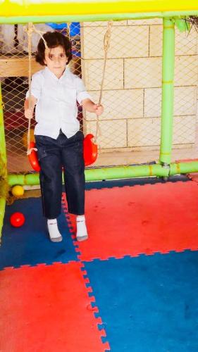 a young girl sitting on a swing in a playground at Dynasty Suite in Aley