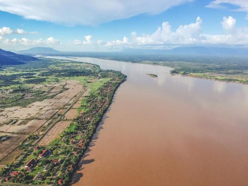 an aerial view of a river with trees and buildings at Residence Bassac in Champasak