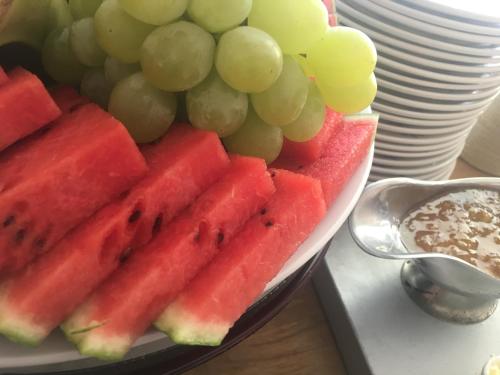 a plate of watermelon and grapes and a plate of nuts at Böda Hotell in Böda