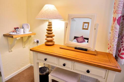 a table with a lamp and a mirror on it at The Talbot Hotel in Cleobury Mortimer