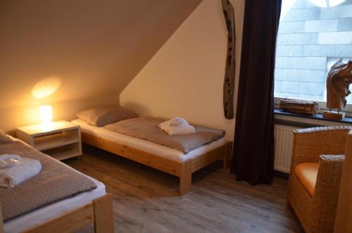 ヘルゴラントにあるHaus Morgenröteのベッド2台と窓が備わる小さな客室です。