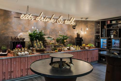 a coffee shop with a table in front of a counter at Mercure Hotel Hamburg City in Hamburg