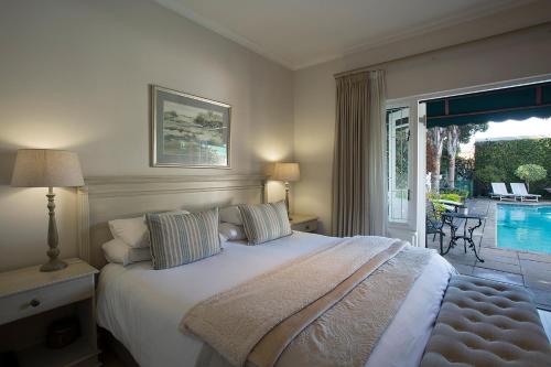a bedroom with a bed and a patio with a pool at Carslogie House in Port Elizabeth