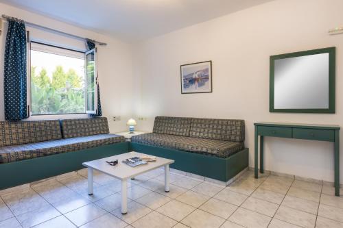 a living room with two couches and a table at Evdokia Suites in Gouves
