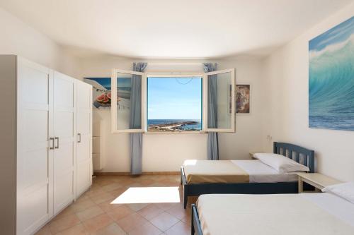 レウカにあるAttico del Blu by BarbarHouseのベッドルーム1室(ベッド2台、窓付)